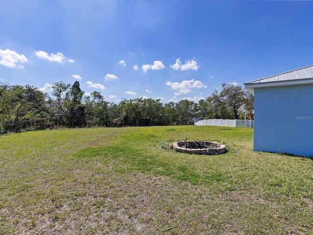 view of yard with fence and a fire pit