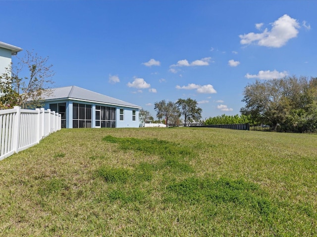 view of yard with a sunroom and fence