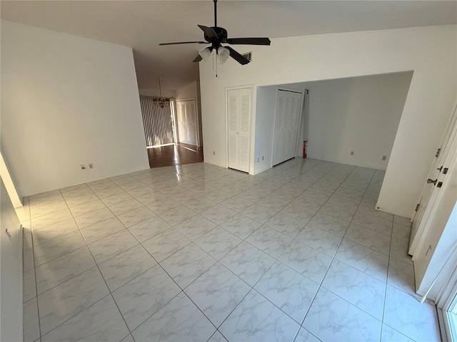 empty room featuring a ceiling fan and vaulted ceiling