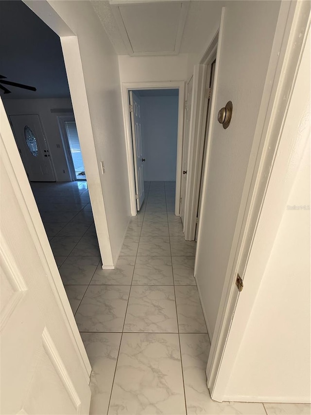 hall with baseboards and marble finish floor