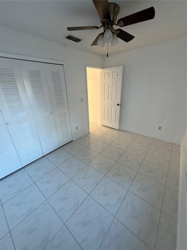 unfurnished bedroom with visible vents, a closet, and a ceiling fan