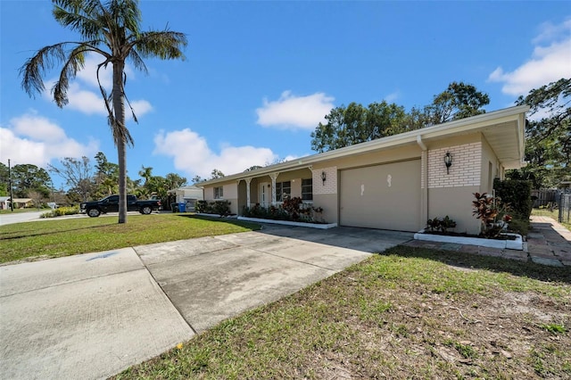 single story home featuring an attached garage, a front yard, concrete driveway, and brick siding