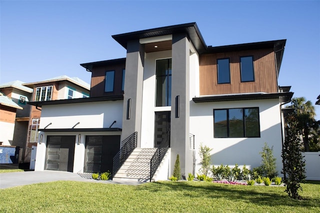 contemporary house with a garage, a front yard, concrete driveway, and stucco siding