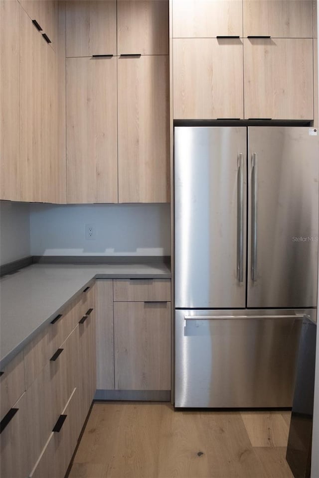 kitchen with light brown cabinets, modern cabinets, and freestanding refrigerator