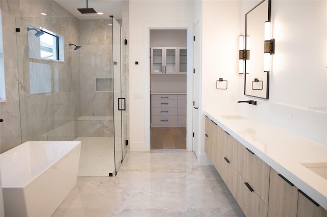 bathroom with double vanity, a shower stall, a freestanding bath, and a sink