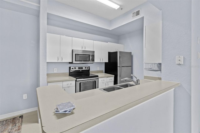 kitchen featuring stainless steel appliances, white cabinets, visible vents, and a sink