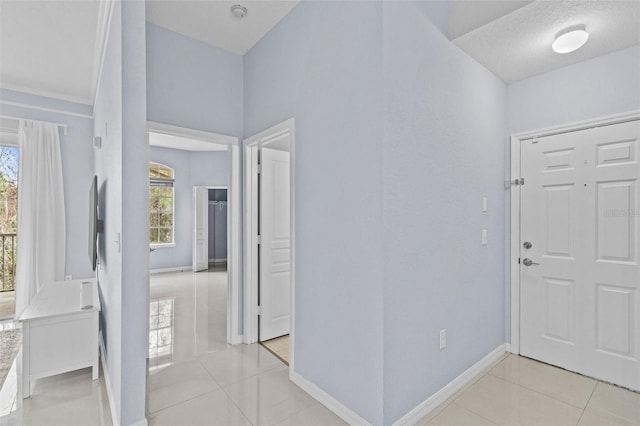 foyer entrance featuring plenty of natural light, baseboards, and light tile patterned floors