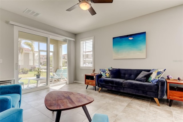 living area featuring visible vents, a ceiling fan, and light tile patterned flooring