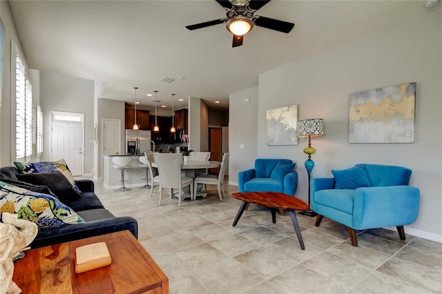 living room with visible vents, plenty of natural light, baseboards, and ceiling fan