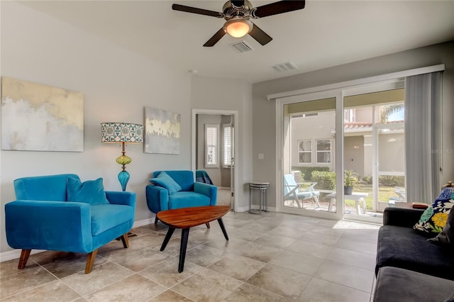 living area with baseboards, visible vents, and a ceiling fan