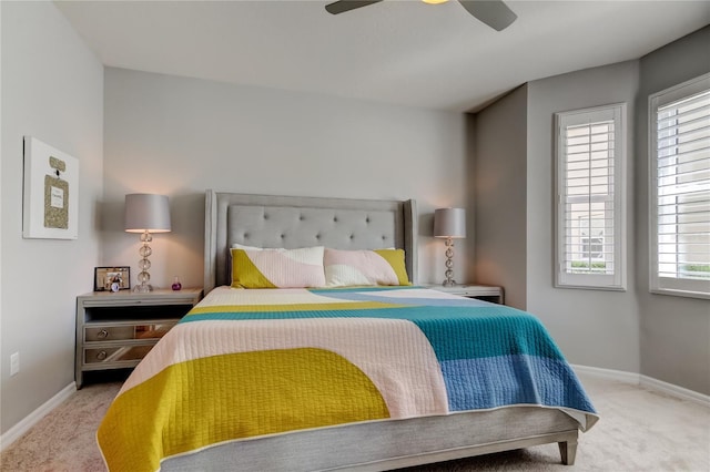 bedroom with a ceiling fan, baseboards, and carpet flooring