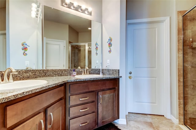 full bathroom featuring double vanity, a stall shower, and a sink