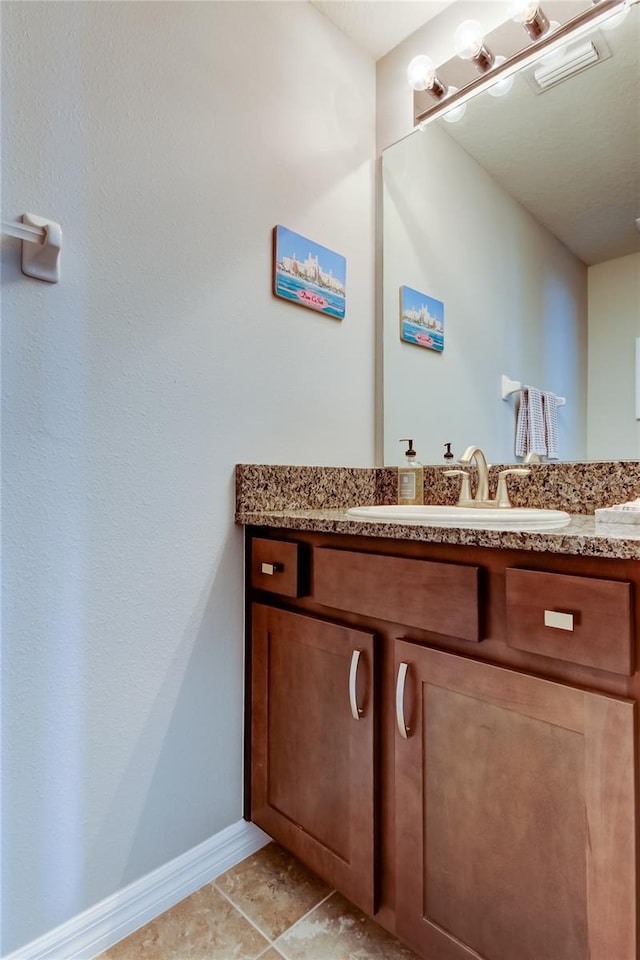 bathroom with tile patterned floors, vanity, and baseboards