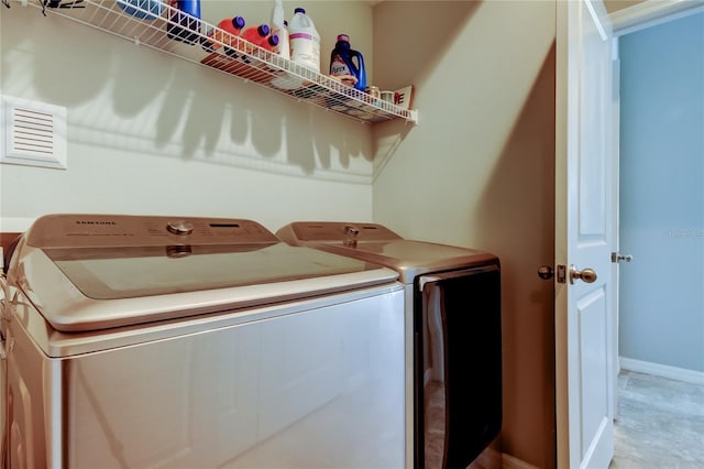 laundry area with laundry area, baseboards, and separate washer and dryer