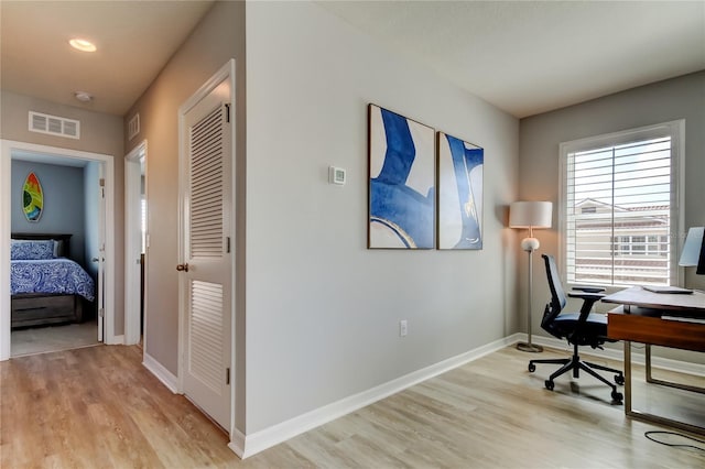 office with baseboards, visible vents, and light wood-style floors