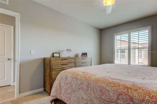 bedroom featuring light carpet, ceiling fan, and baseboards