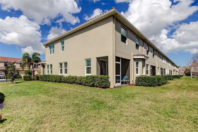 view of side of property featuring stucco siding and a yard