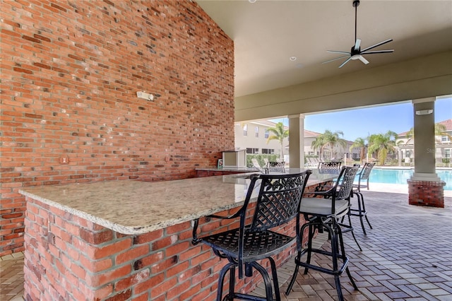 view of patio / terrace with ceiling fan, a community pool, and outdoor wet bar