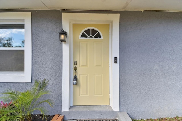 view of exterior entry with stucco siding