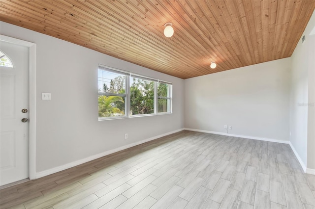 empty room featuring light wood-type flooring, wood ceiling, and baseboards