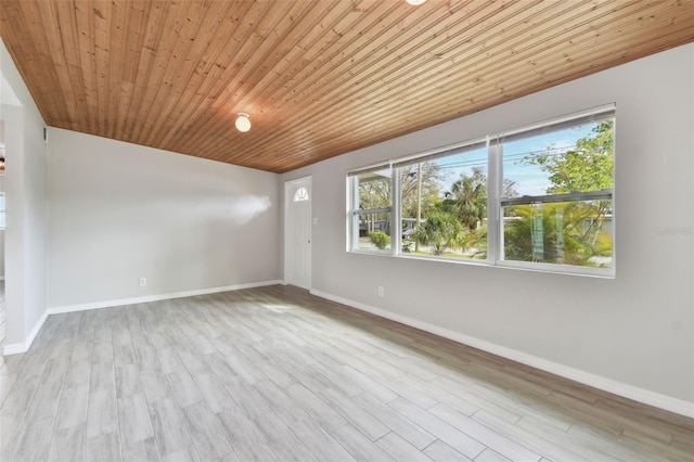 empty room featuring wooden ceiling, wood finished floors, and baseboards