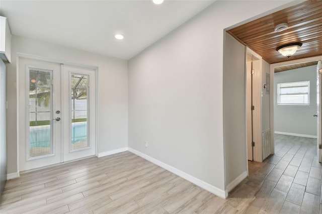 interior space featuring light wood-style floors, recessed lighting, french doors, and baseboards