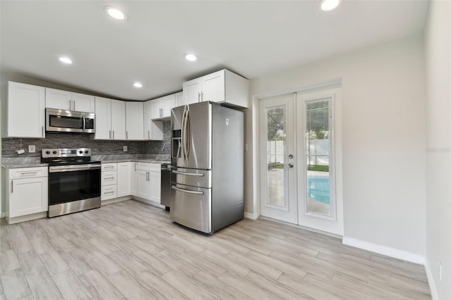 kitchen with recessed lighting, white cabinetry, french doors, appliances with stainless steel finishes, and decorative backsplash