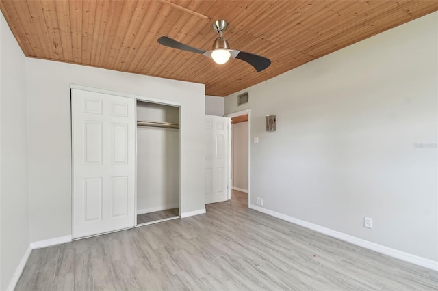 unfurnished bedroom featuring baseboards, visible vents, wooden ceiling, wood finished floors, and a closet