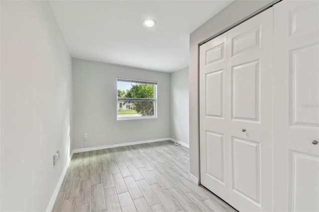 unfurnished bedroom featuring light wood-type flooring and baseboards