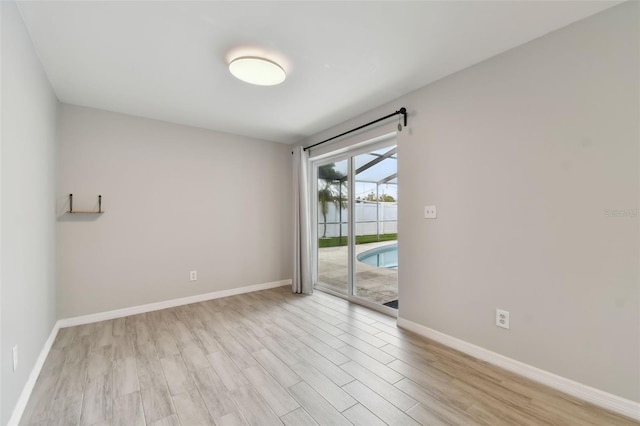 unfurnished room featuring light wood-style flooring and baseboards