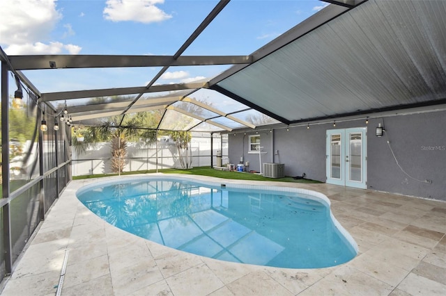 view of pool with french doors, a patio area, glass enclosure, cooling unit, and a fenced backyard