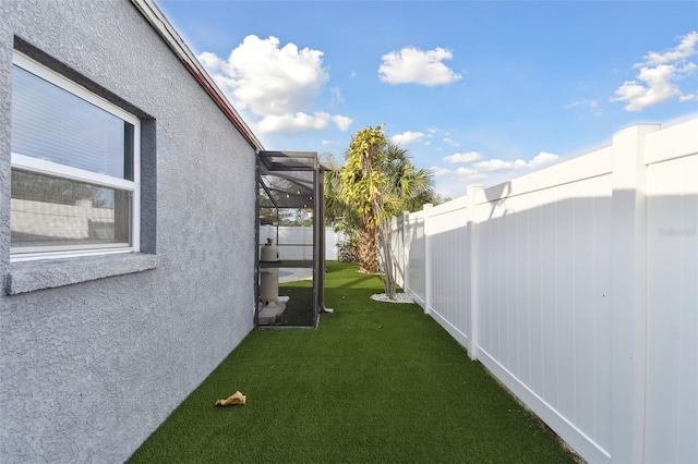 view of yard with fence and a lanai