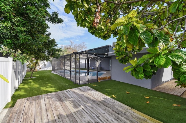 wooden terrace featuring glass enclosure, a fenced backyard, a fenced in pool, and a yard