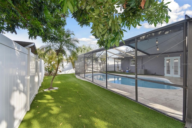 view of pool with a fenced in pool, french doors, a fenced backyard, a lanai, and a yard