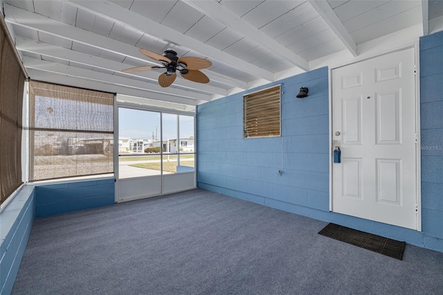 unfurnished sunroom with a ceiling fan and beamed ceiling