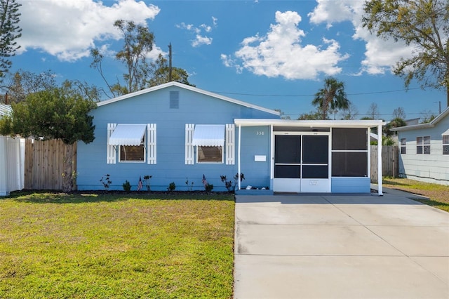 single story home with a front lawn, fence, and a sunroom