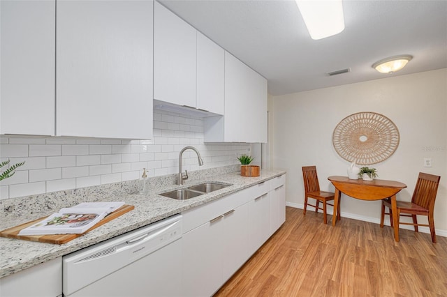 kitchen with light wood finished floors, visible vents, white cabinetry, a sink, and dishwasher