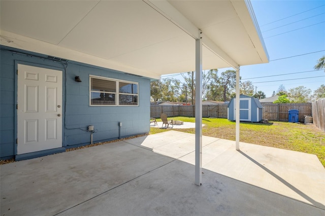 view of patio / terrace with a fenced backyard, an outdoor structure, and a storage unit