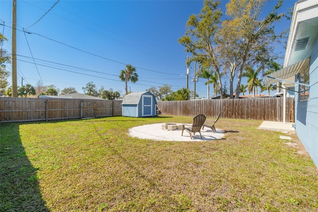 view of yard with an outdoor fire pit, a patio, a fenced backyard, an outdoor structure, and a shed