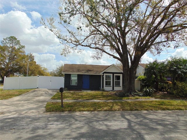 view of front of house featuring concrete driveway, fence, and a gate