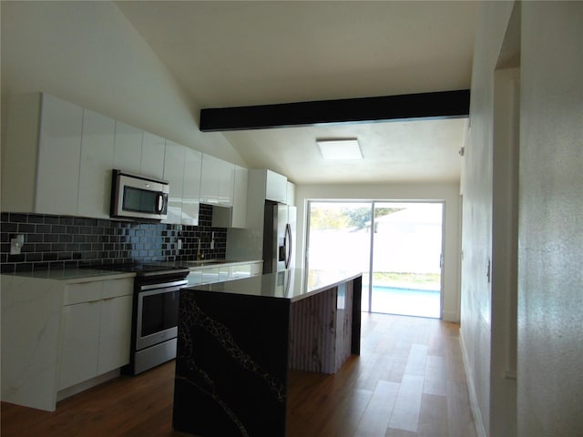 kitchen featuring white cabinets, decorative backsplash, modern cabinets, wood finished floors, and stainless steel appliances