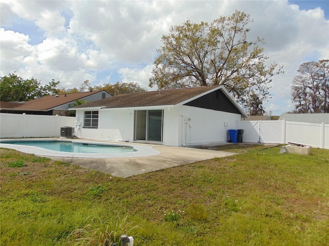 rear view of house featuring a patio, central AC unit, a fenced backyard, a lawn, and a gate