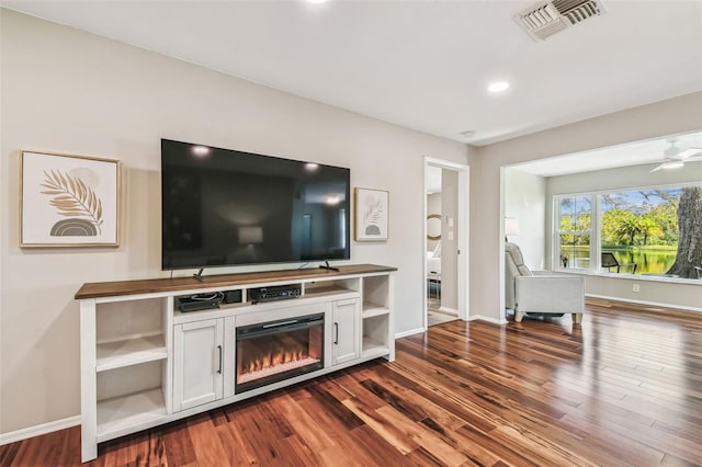 living area featuring baseboards, visible vents, and dark wood-style flooring