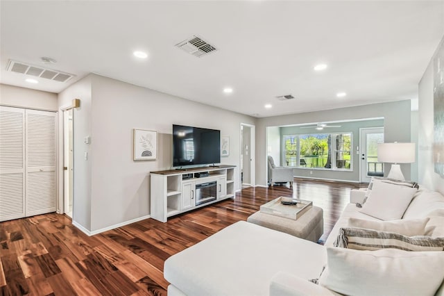 living room with recessed lighting, visible vents, and wood finished floors