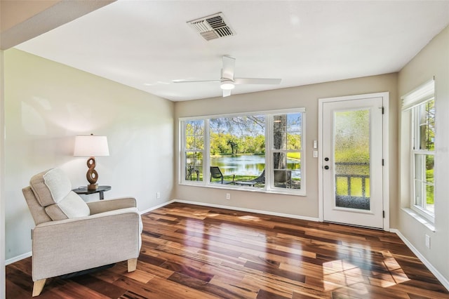 living area featuring visible vents, a healthy amount of sunlight, and wood finished floors