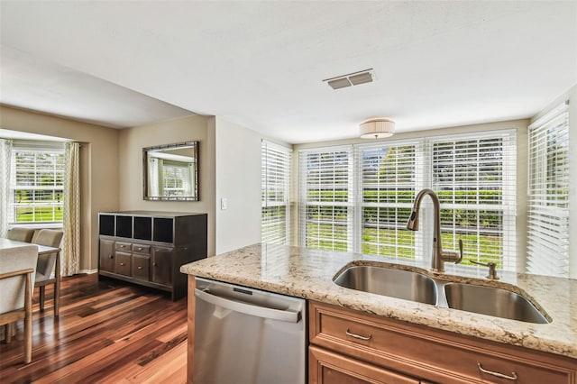 kitchen featuring visible vents, brown cabinets, a sink, stainless steel dishwasher, and dark wood-style flooring