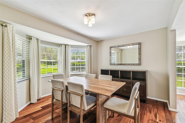 dining space featuring dark wood finished floors and baseboards