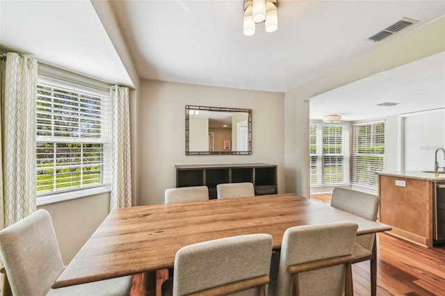 dining area with wood finished floors and visible vents