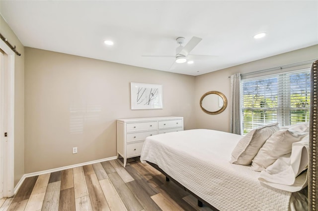 bedroom with light wood finished floors, recessed lighting, a ceiling fan, and baseboards