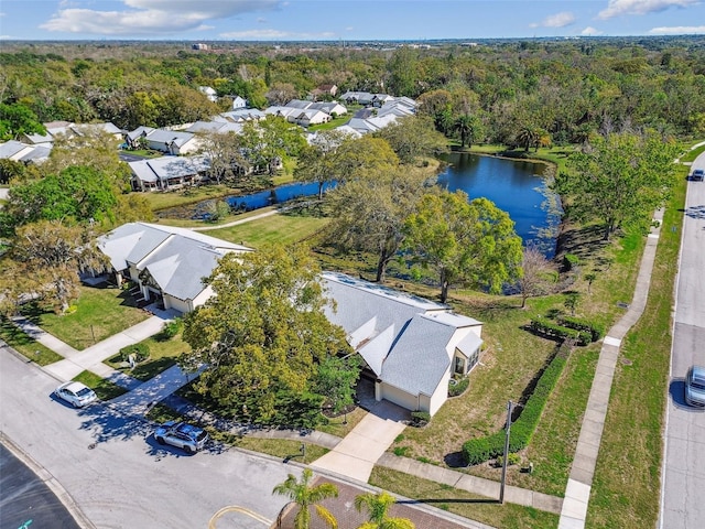 drone / aerial view featuring a forest view, a water view, and a residential view